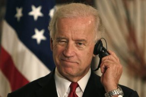 President Joseph Biden jamming a phallic device in his ear.